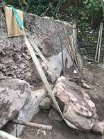 Der Findling wird über die Steinrampe an die Vorderkante der Mauer gezogen.