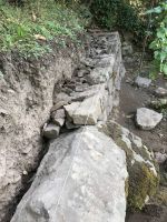 Das rechte Mauersegment hat die Höhe des Findlings erreicht.